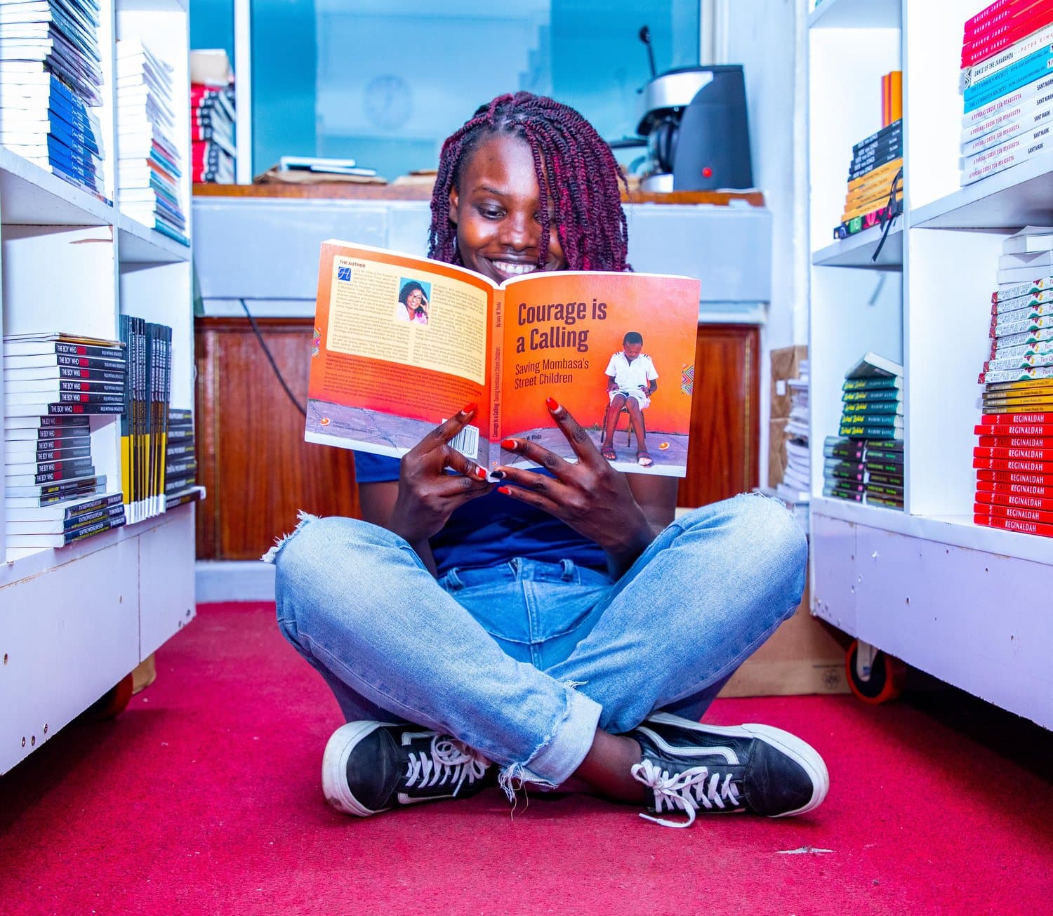 A reader sitting with a copy of Courage is a Calling open in a bookshop