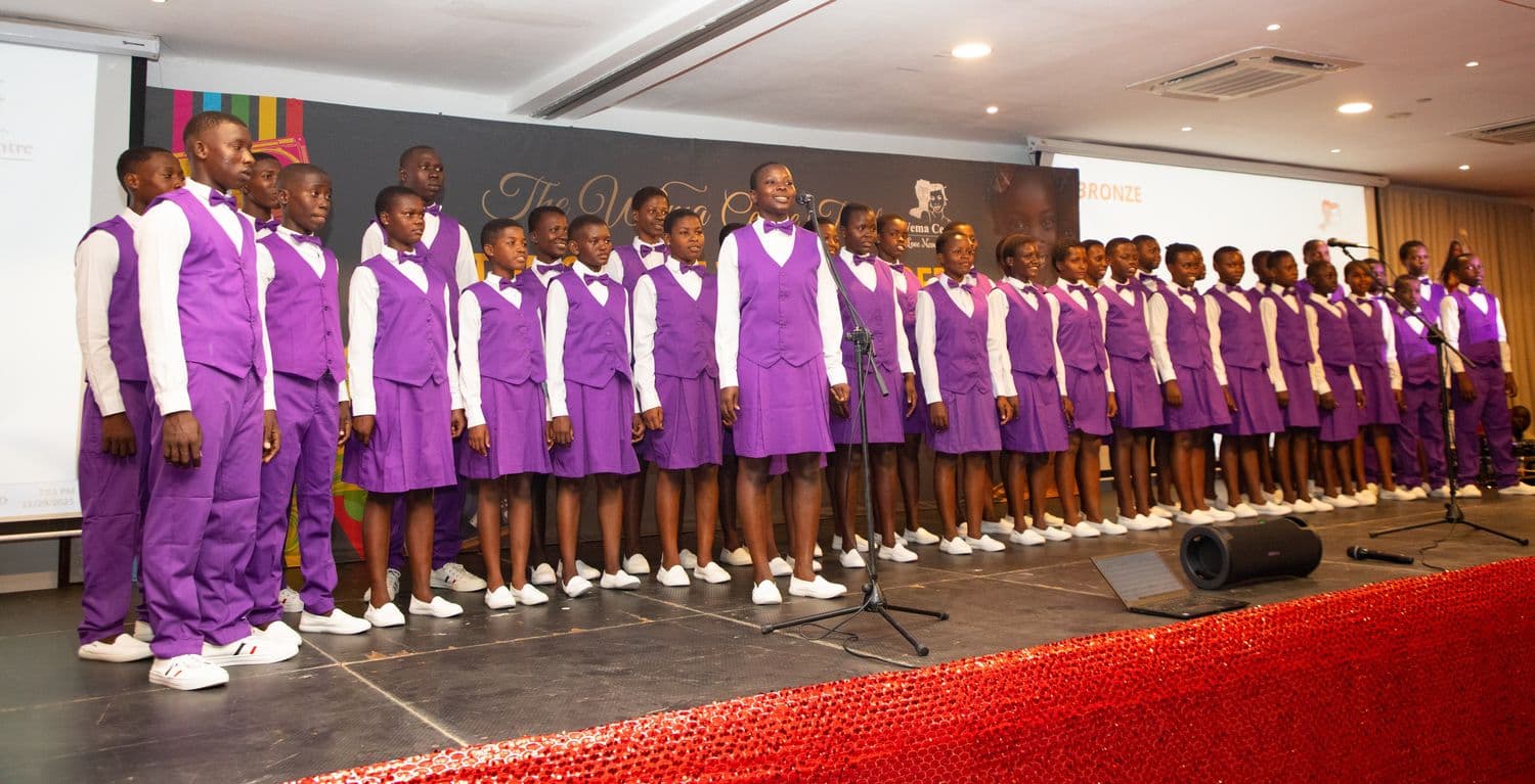 Members of the Wema choir performing in their purple and white uniforms