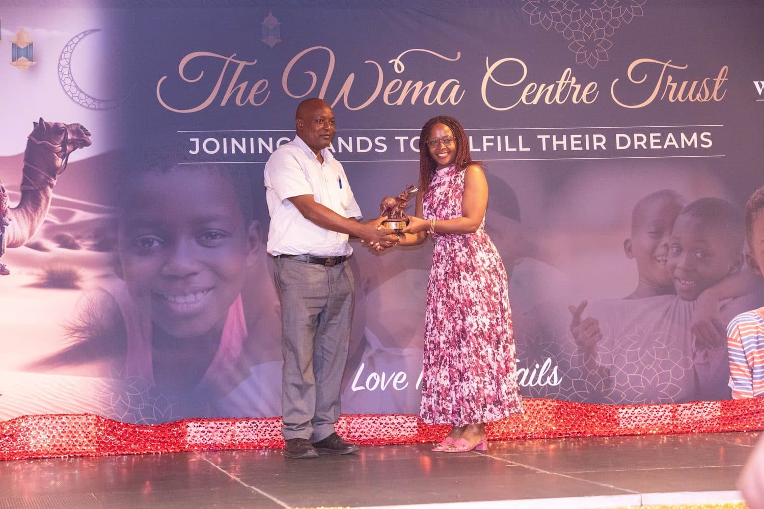 A couple presented on stage at the Wema Gala Dinner
