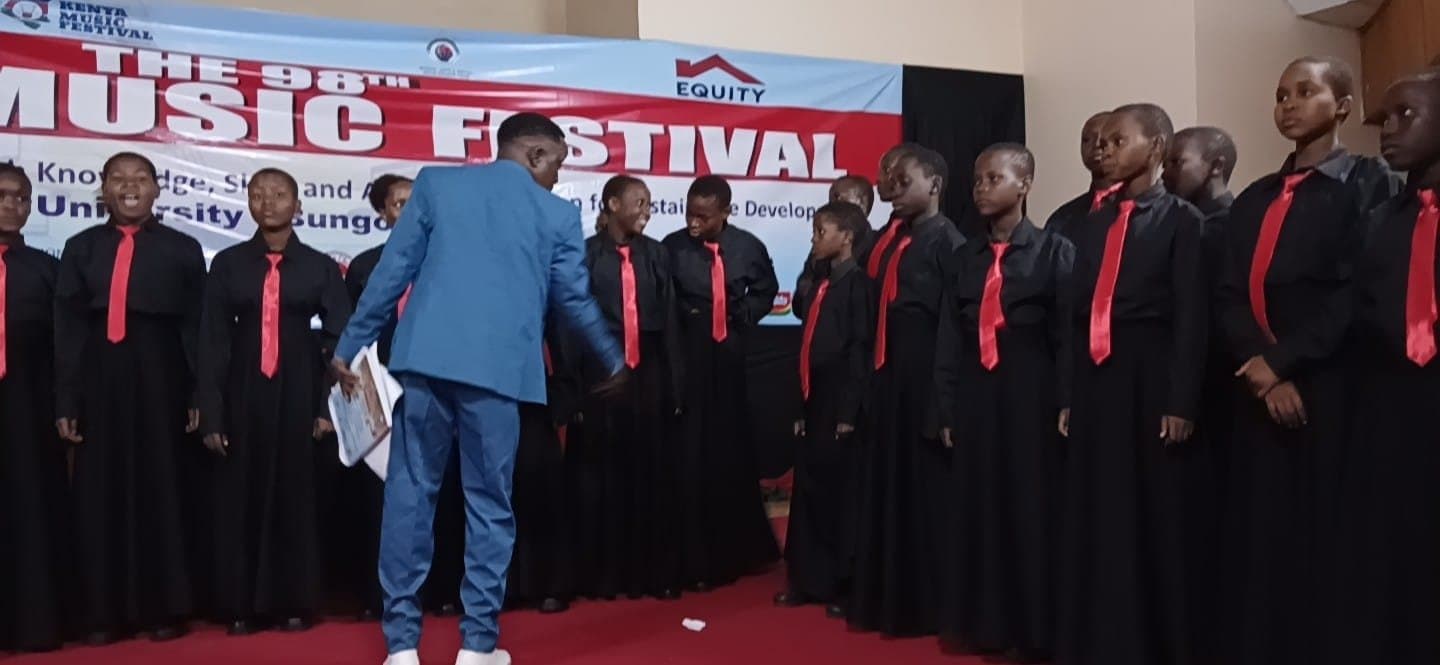 The choir's conductor leading the performance at Kibabii University